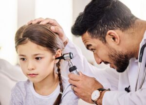 Médico examinando liquido no ouvido de uma criança